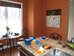 The highlight of this blue and orange kitchen is the Grey Zeien painting on the wall.